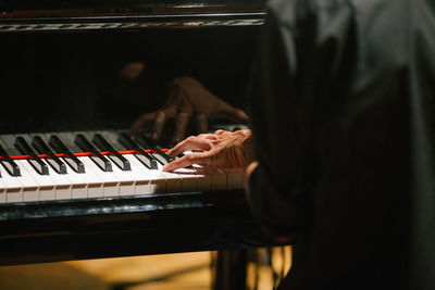 Midsection of man playing piano