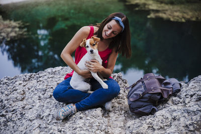 Young woman with dog sitting outdoors
