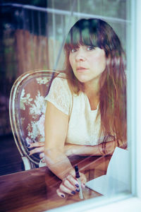 Close-up portrait of young woman sitting at home