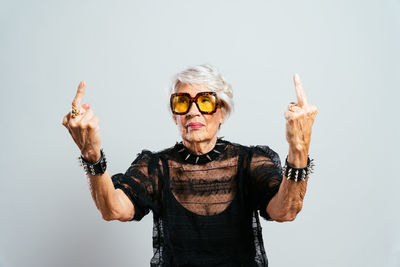 Portrait of young woman wearing sunglasses against white background