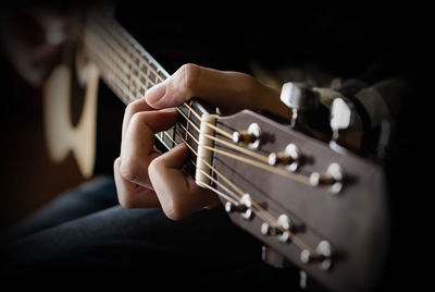 Midsection of man playing guitar