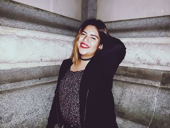 Portrait of beautiful young woman standing on steps