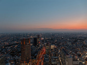 High angle view of illuminated cityscape against sky during sunset