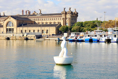 Boats in river with buildings in background