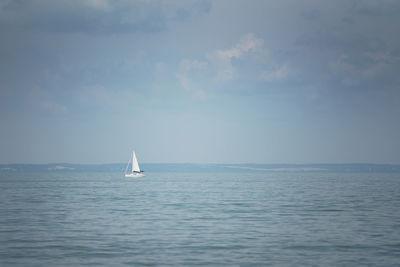 Sailboat sailing on sea against sky