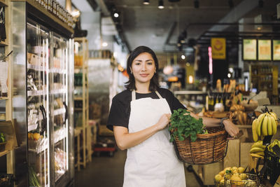 Portrait of young woman standing in supermarket