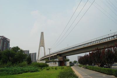 Low angle view of bridge against cloudy sky