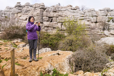 Woman photographing against rock formations