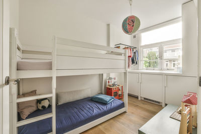 Rear view of woman sitting on bed at home