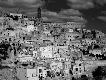Buildings in town against cloudy sky