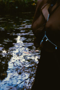 Midsection of woman standing by lake