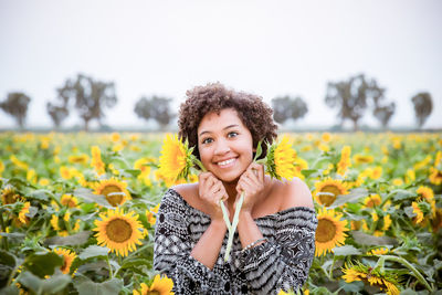 Portrait of smiling young woman standing on field