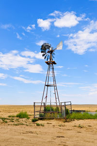 Traditional windmill on field against sky