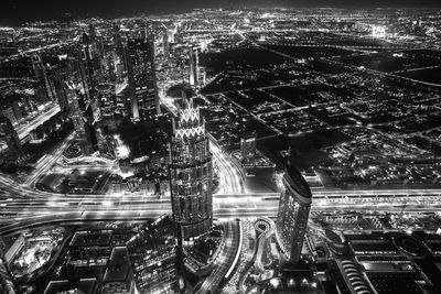 High angle view of illuminated street amidst buildings in city at night