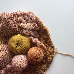 Balls of wool with crochet on white table