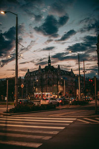 View of city street against cloudy sky