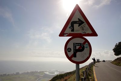 Road sign against sky