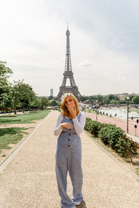 Full length of woman standing against tower
