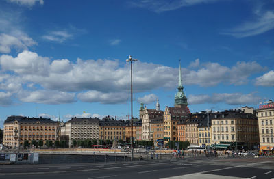 Buildings in city against cloudy sky