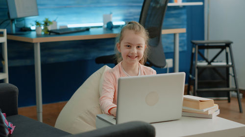 Portrait of girl sitting on table