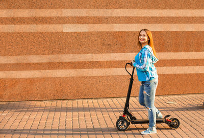 Portrait of smiling girl walking on sidewalk in city