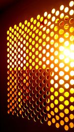 Close-up of illuminated lighting equipment against black background