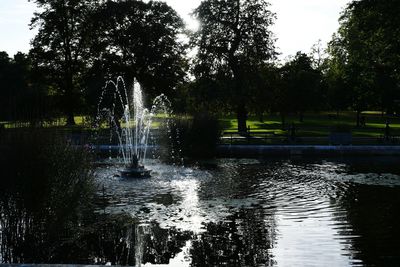 Fountain in swimming pool against sky