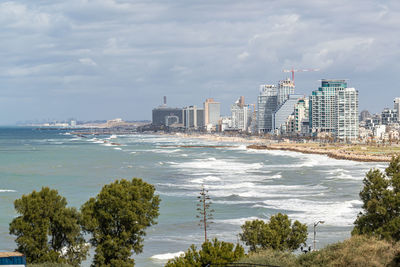 Scenic view of sea and buildings against sky