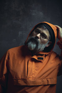 Portrait of man wearing hat standing against wall