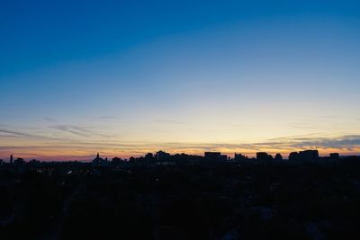 Silhouette buildings against sky during sunset