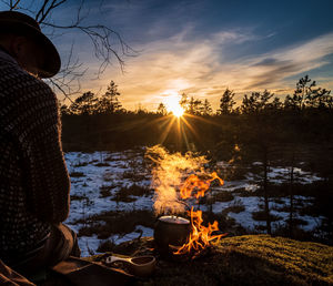 Rear view of man preparing food outdoors