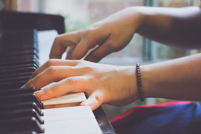 Close-up of hands playing piano