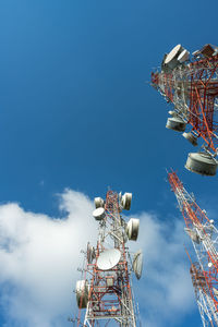 Low angle view of communications tower against blue sky