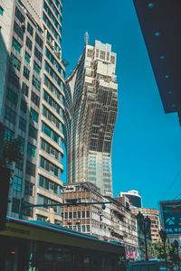 Low angle view of modern buildings against clear blue sky