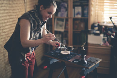 Needlewoman puts the wire in boiling water, the concept of creativity and home workshop, the process 