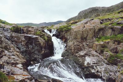 Scenic view of waterfall against sky