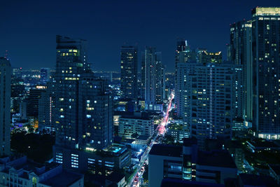 Illuminated buildings in city against sky at night