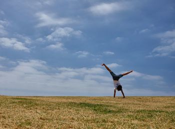 Full length of woman walking on field against sky