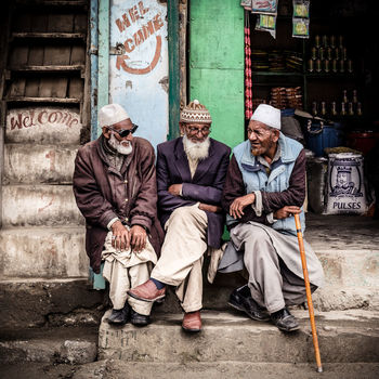 PEOPLE SITTING ON WALL WITH TEXT