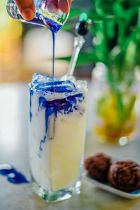 Iced butterfly tea milk in glass and chocolate brownie cookies on white table.delicious homemade