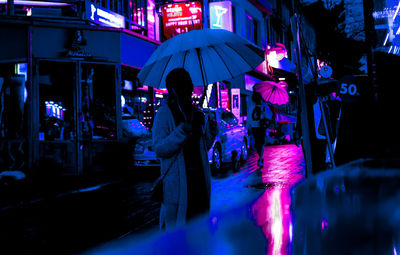 People in illuminated town square at night