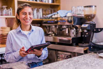 Portrait of smiling businesswoman using digital tablet at cafe