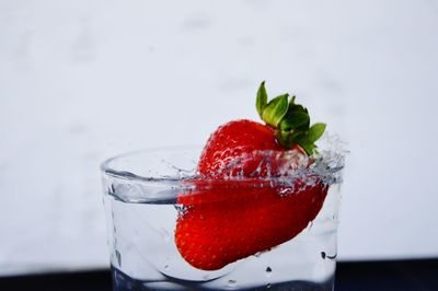 Close-up of strawberry in water glass on table