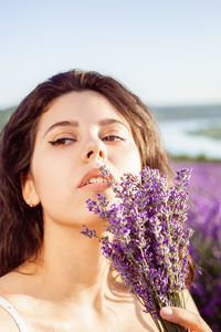 A beautiful young girl against the sunset and a beautiful sky in a lavender field. 