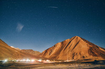 Scenic view of illuminated mountains against sky at night