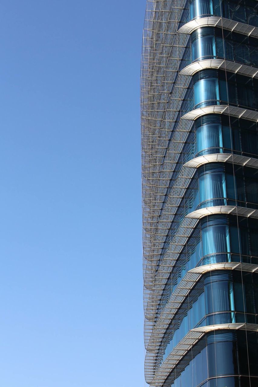 low angle view, building exterior, architecture, built structure, clear sky, building, modern, tall - high, city, skyscraper, tower, office building, blue, day, outdoors, no people, copy space, part of, tall, window