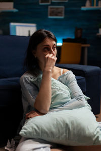 Frustrated woman sitting on sofa at home