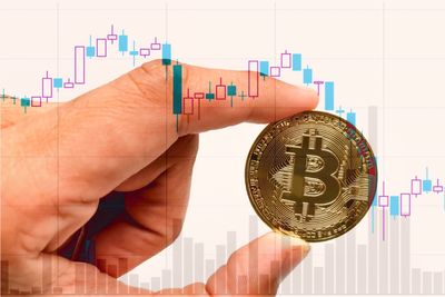 Double exposure of cropped hand holding bitcoin and graph