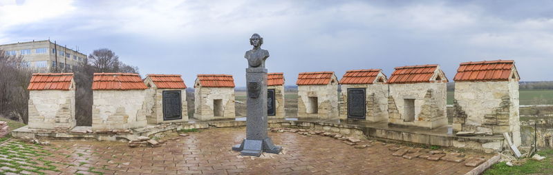 Statue against buildings in city against sky