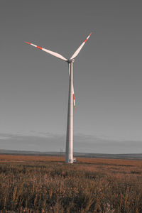 Windmill on field against sky